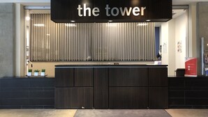 A reception desk with a sign reading "the tower" above it. - Residence & Conference Centre - Calgary (Calgary)