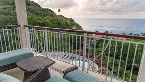 A balcony with wicker furniture and a view of the ocean. - Villa Hall (Gros Islet)