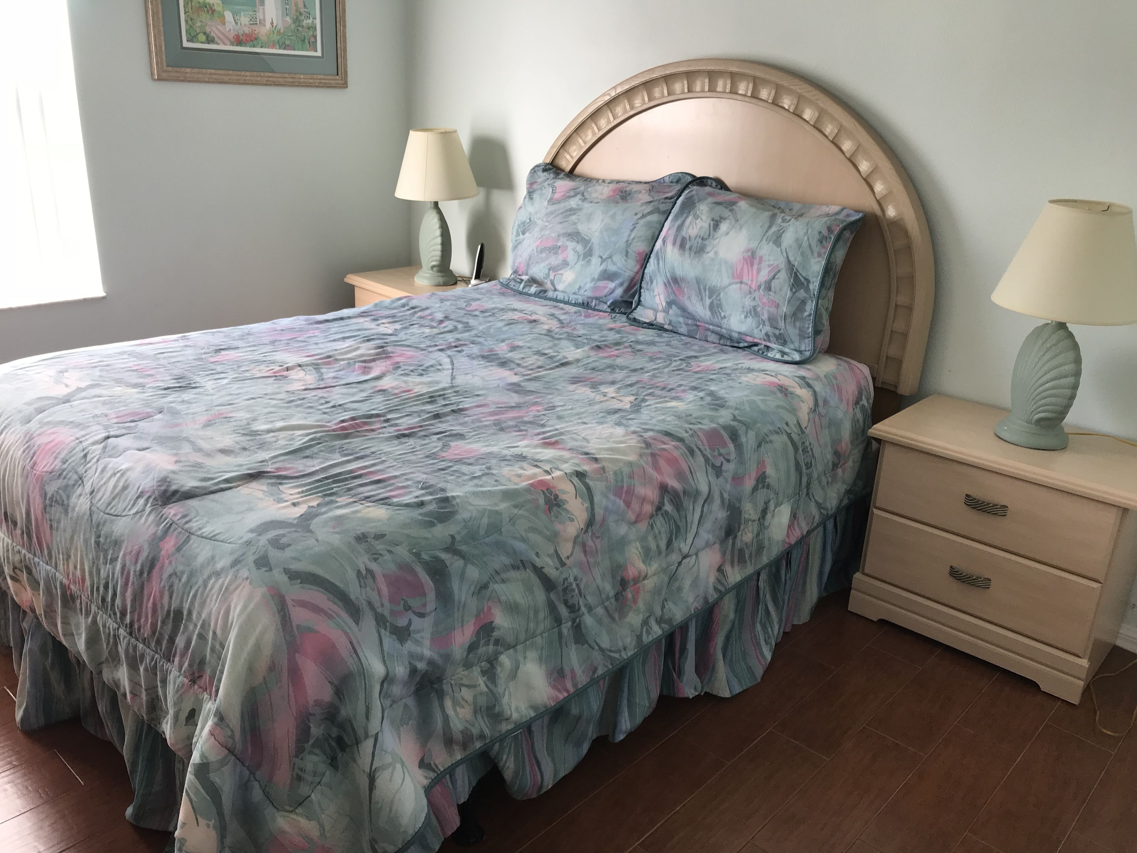 A bedroom with a bed, two nightstands, and a night lamp.
