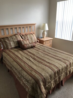Cozy retreat with a large bed, wooden headboard, and bedside table.