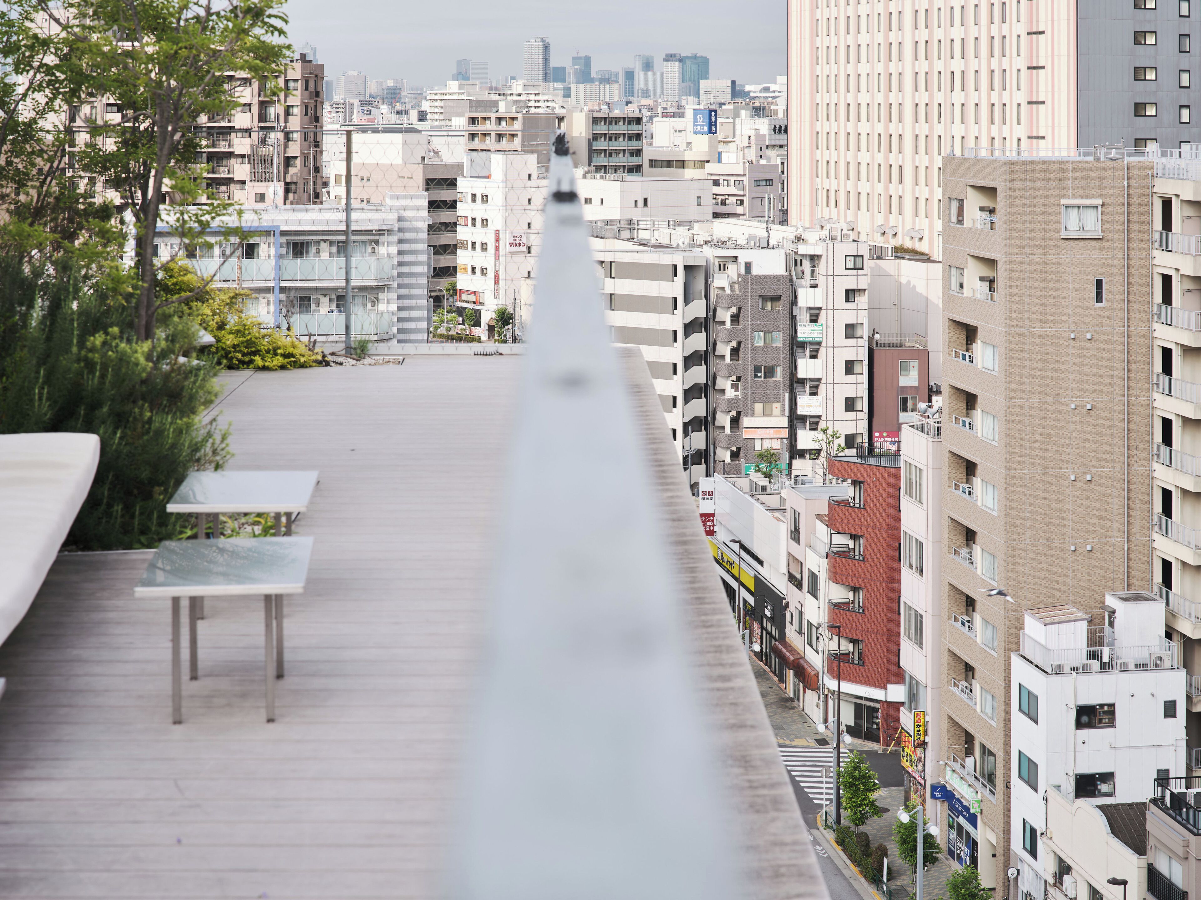 A high-rise building with multiple floors, balconies, and a view of a cityscape.