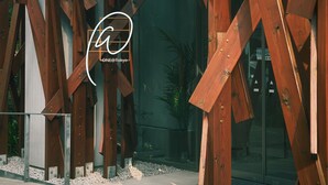 A modern building with wooden beams and metal supports, a glass entrance, and a sign reading "ONE@Tokyo". - ONE＠Tokyo by insomnia (Tokyo)