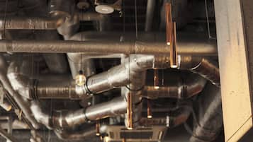 A complex network of metallic pipes and ducts, likely part of a building's HVAC system.