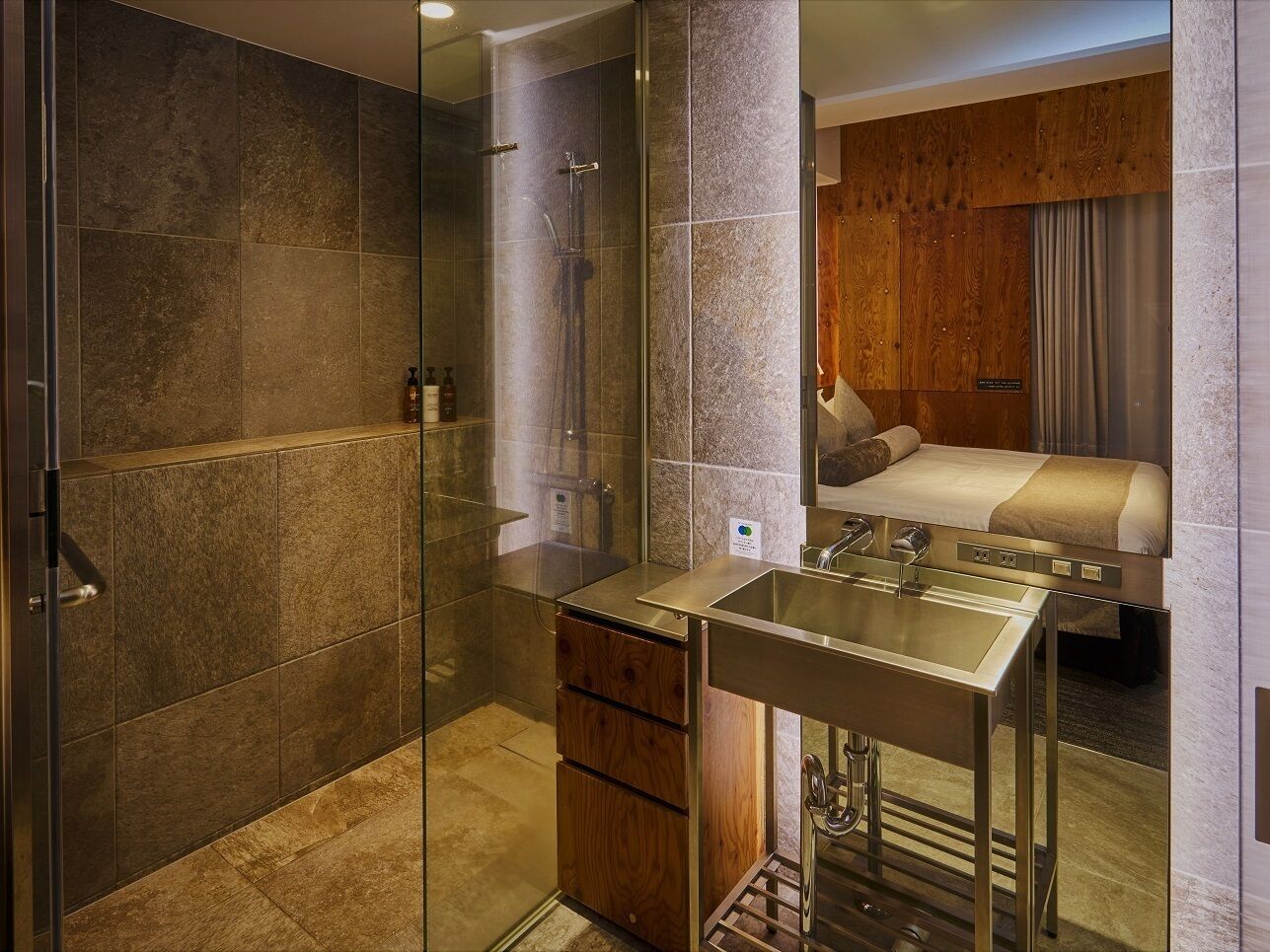 Une salle de bain moderne avec une douche à parois de verre, un lavabo avec un miroir et un meuble en bois.