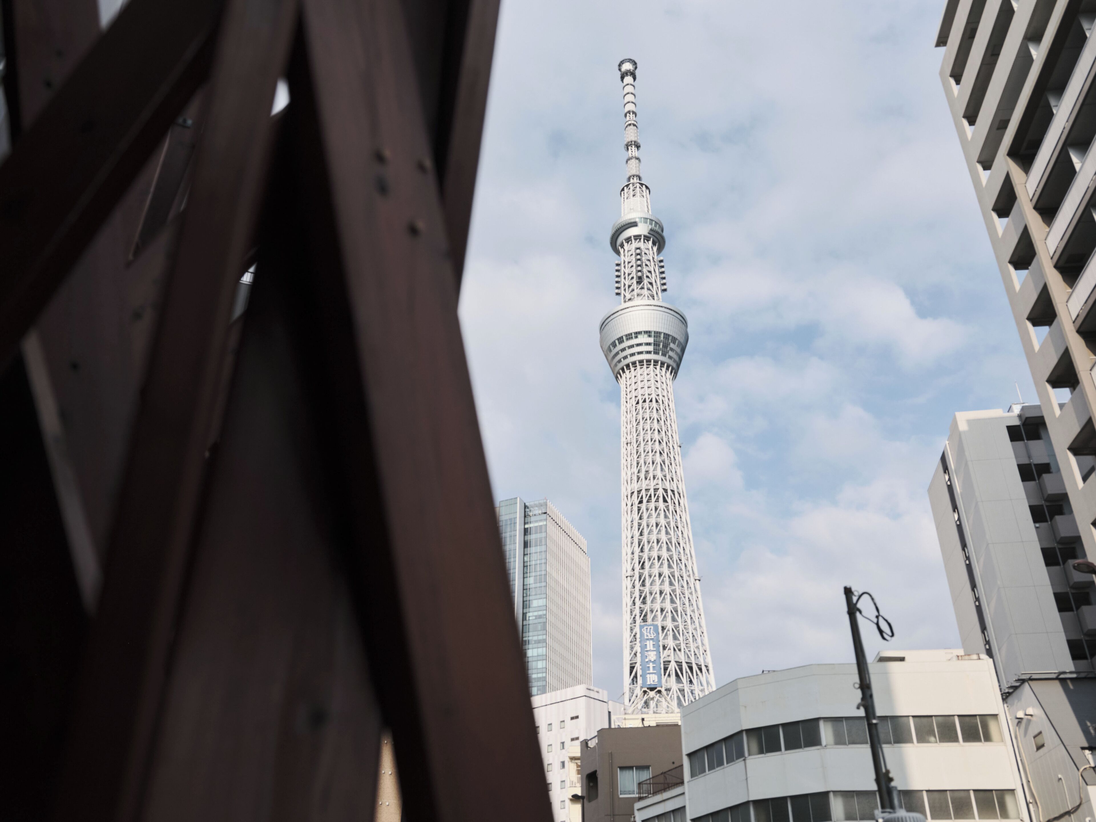 A tall tower with a spiral design, surrounded by modern buildings.