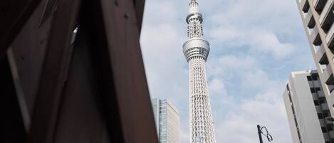 A tall tower with a spiral design, surrounded by modern buildings.