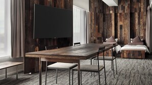 A modern hotel room with a large wooden wall panel, a flat-screen TV, a wooden dining table, and a cozy seating area. - ONE＠Tokyo by insomnia (Tokyo)