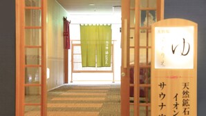 Una habitación japonesa tradicional con suelo de tatami, un mamparas shoji y un cartel con caracteres japoneses.
