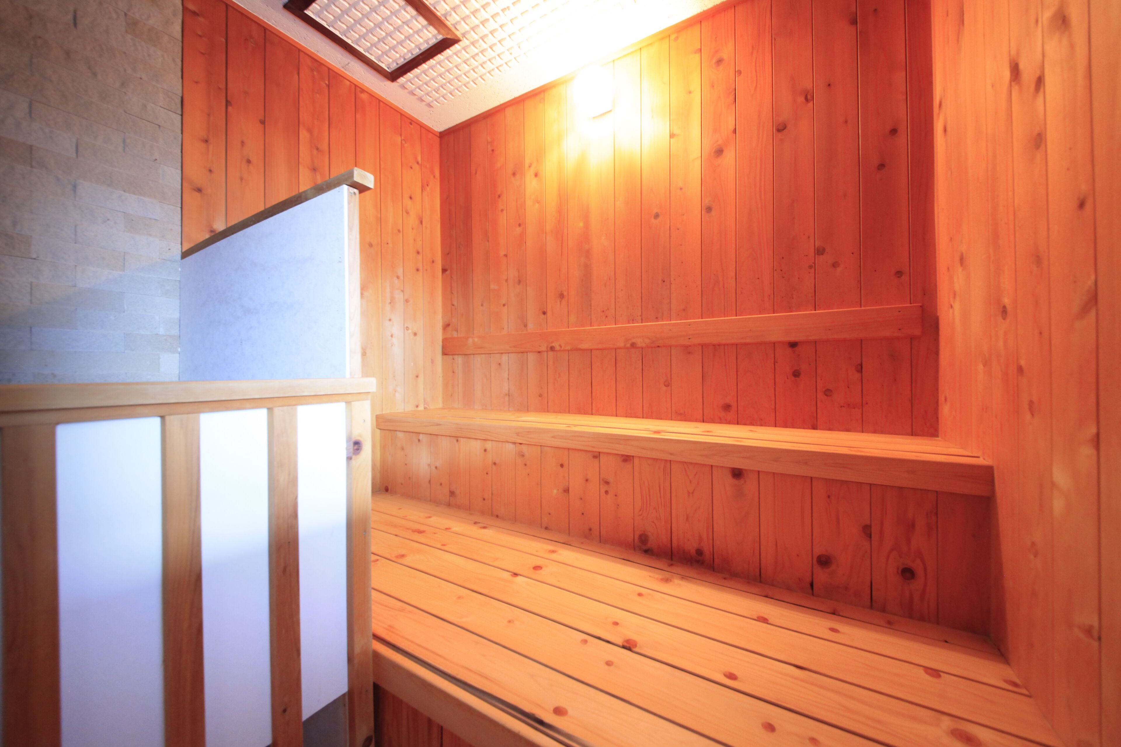 Un sauna en bois, doté de bancs et d’un plafond incliné.