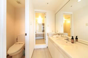 Un baño moderno con inodoro, lavamanos y espejo.