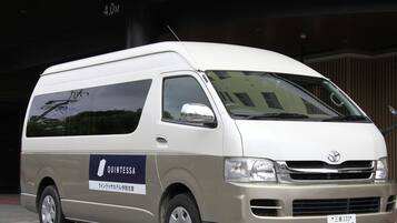 A white van with a blue and white logo on the side, parked in front of a building.