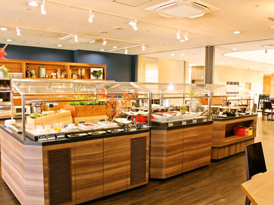 A buffet area with multiple food stations, wooden counters, and a variety of dishes displayed in clear containers.
