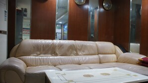 Un sofá de cuero color beige con una mesa blanca al frente.