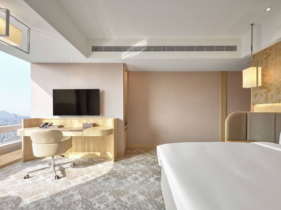 Une chambre d’hôtel équipée d’un lit, d’un bureau, d’une chaise et d’un téléviseur.