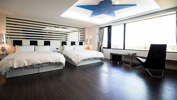 A modern hotel room with a large bed, a desk, and a chair. - Season Skyline (Luodong)