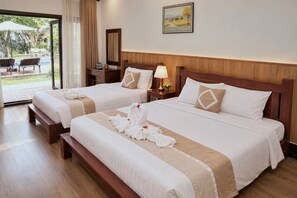 Habitación de hotel con dos camas, cabecera de madera, mesita de noche con lámpara y un cuadro en la pared.