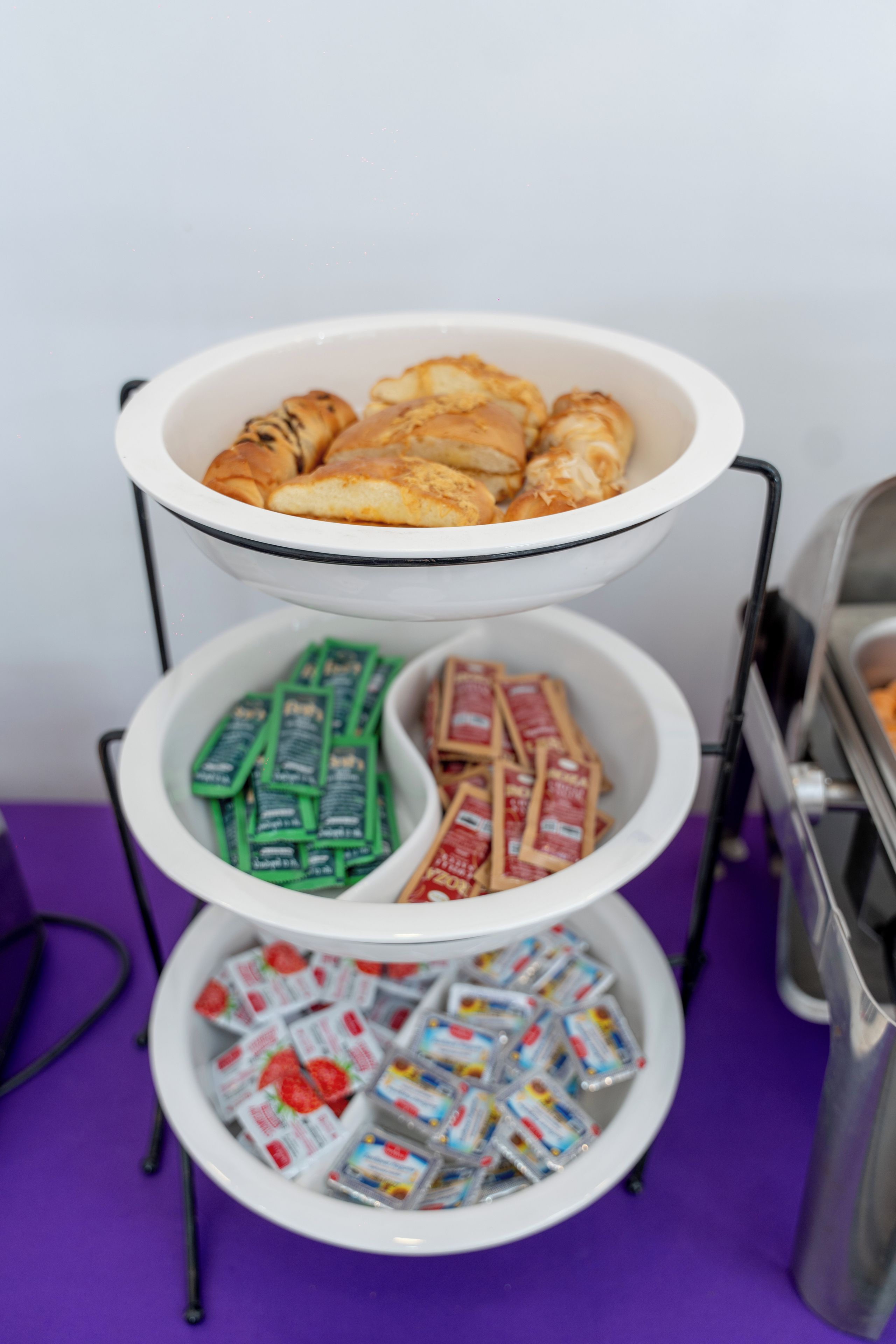 A buffet setup with a tiered serving tray holding various food items.