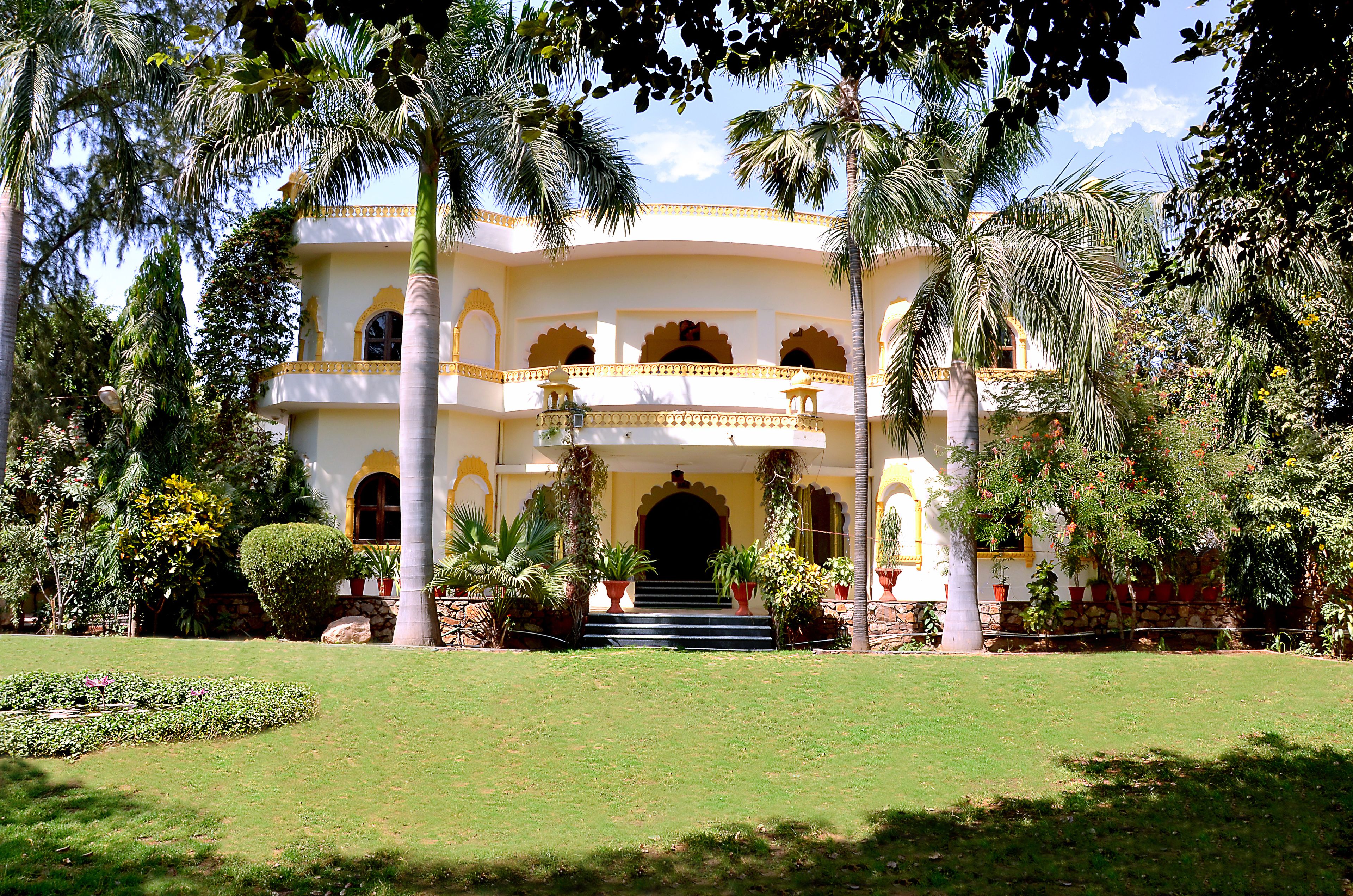 A large, multi-story building with a symmetrical facade, multiple balconies, and a central entrance with steps.