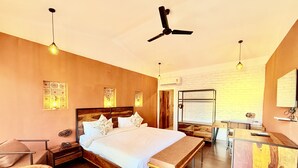 A modern hotel room with a large bed, a desk, and a ceiling fan. - Raj Palace Resort (Sawai Madhopur)