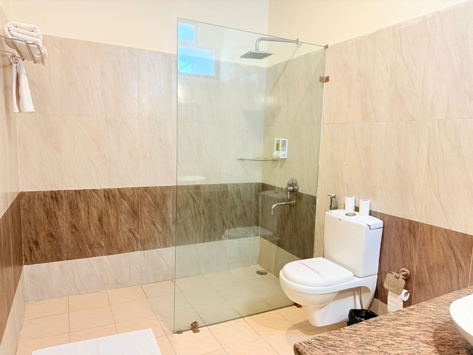 Ein modernes Badezimmer mit Duschkabine aus Glas, Toilette und Waschbecken.