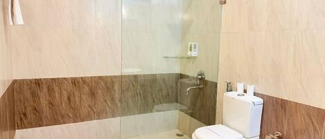 Ein modernes Badezimmer mit Duschkabine aus Glas, Toilette und Waschbecken.