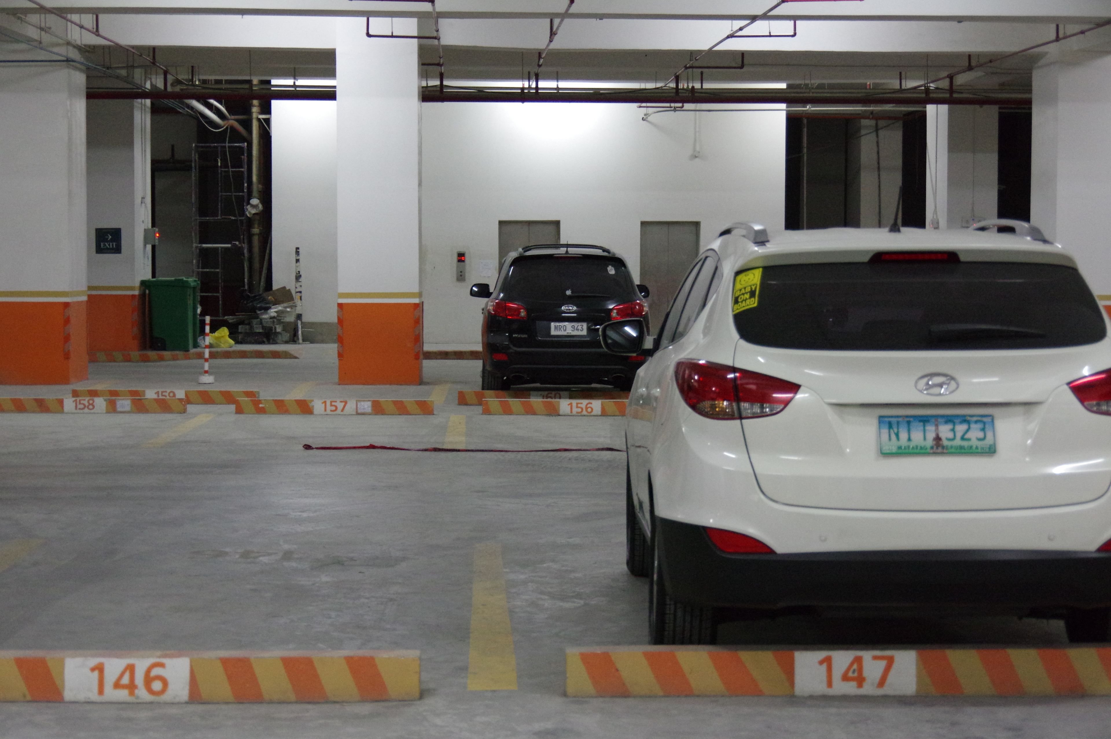 Un garaje para coches con dos vehículos estacionados en sus plazas.