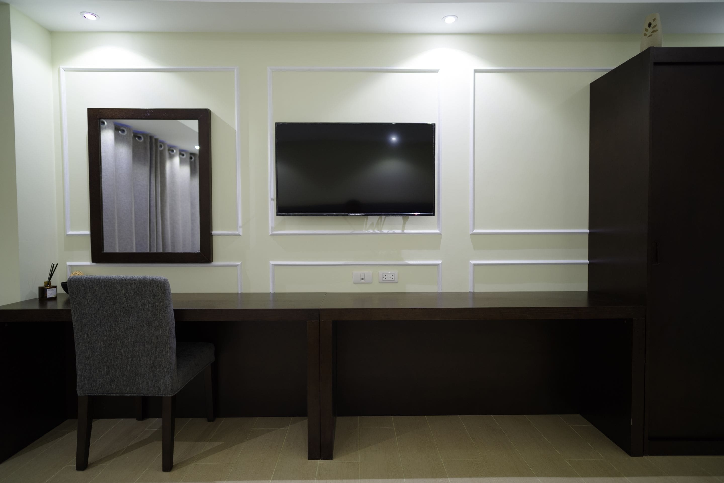 Een moderne kantoorruimte met een bureau, stoel en twee monitoren.