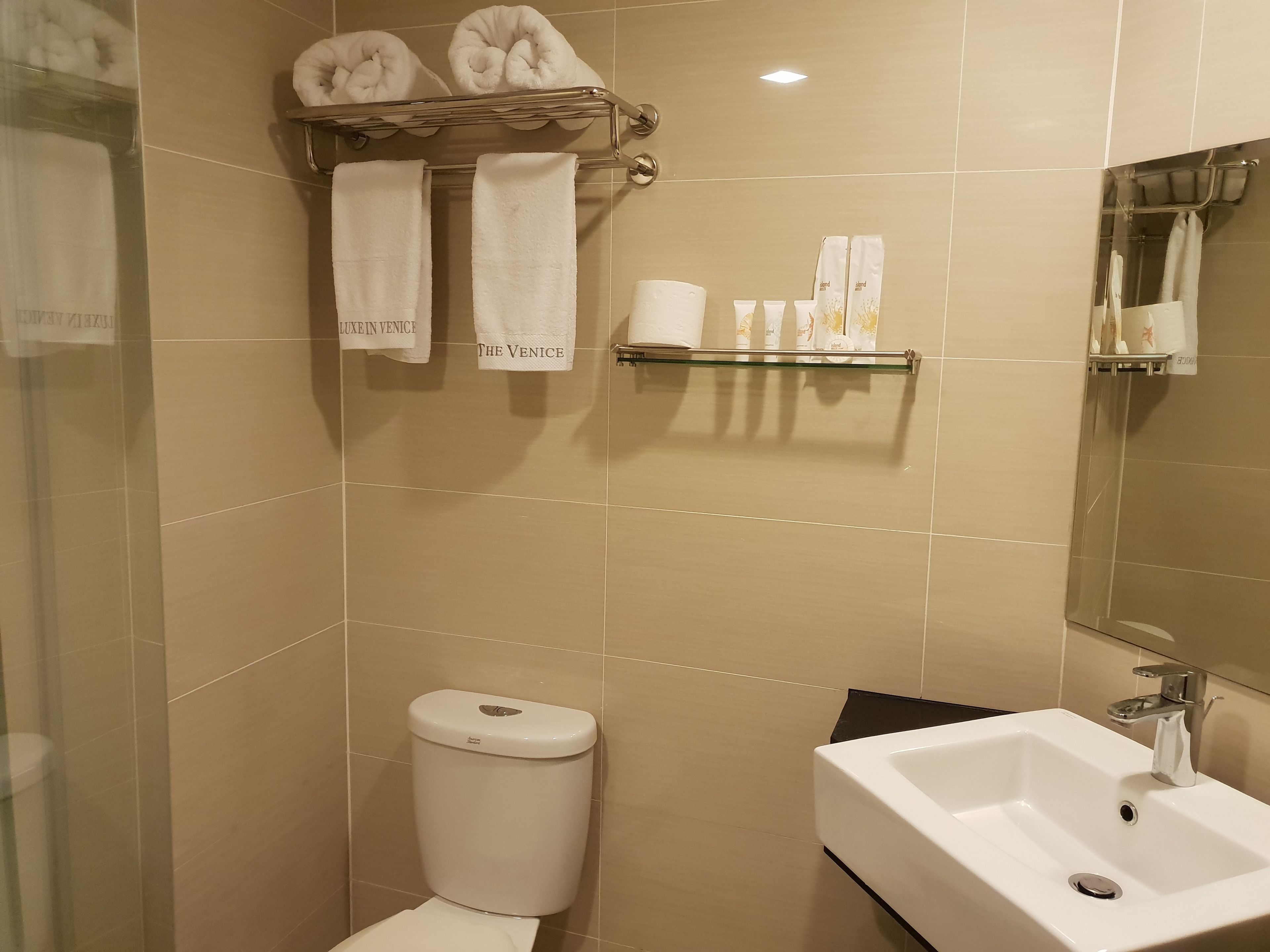 A bathroom with a toilet, sink, and towel rack.