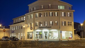 A multi-story building with a storefront labeled "Eymundsson." - Hotel Eyjar (Vestmannaeyjar)