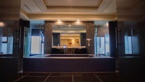 A modern hotel lobby with a reception desk, marble walls, and a large mirror. - OHYA Chain Boutique Motel-Taoyuan  (Taoyuan City)