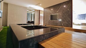 A modern bathroom with a large bathtub, wooden bench, and a TV mounted on the wall. - OHYA Chain Boutique Motel-Taoyuan  (Taoyuan City)
