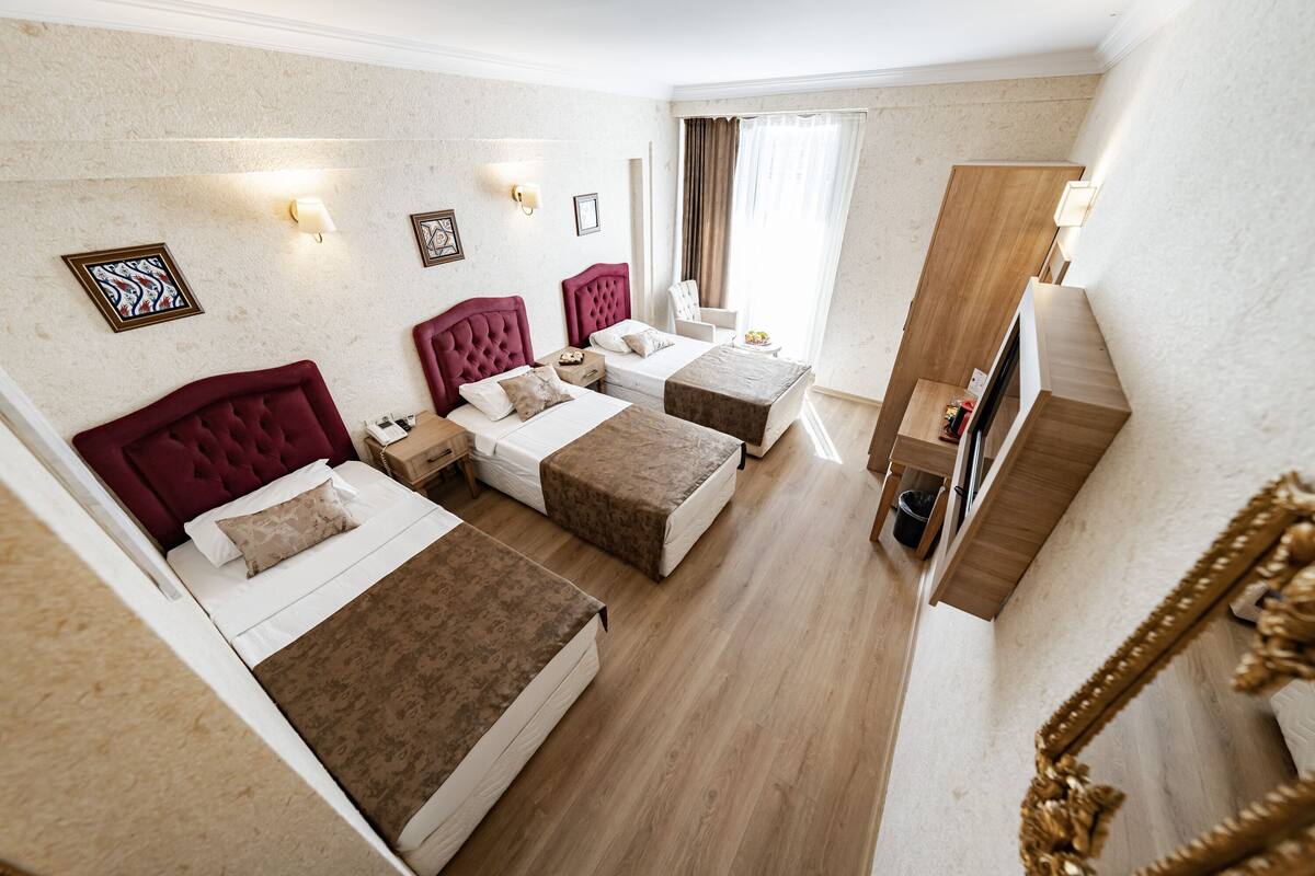 A hotel room with two beds, a vanity, and a large mirror.