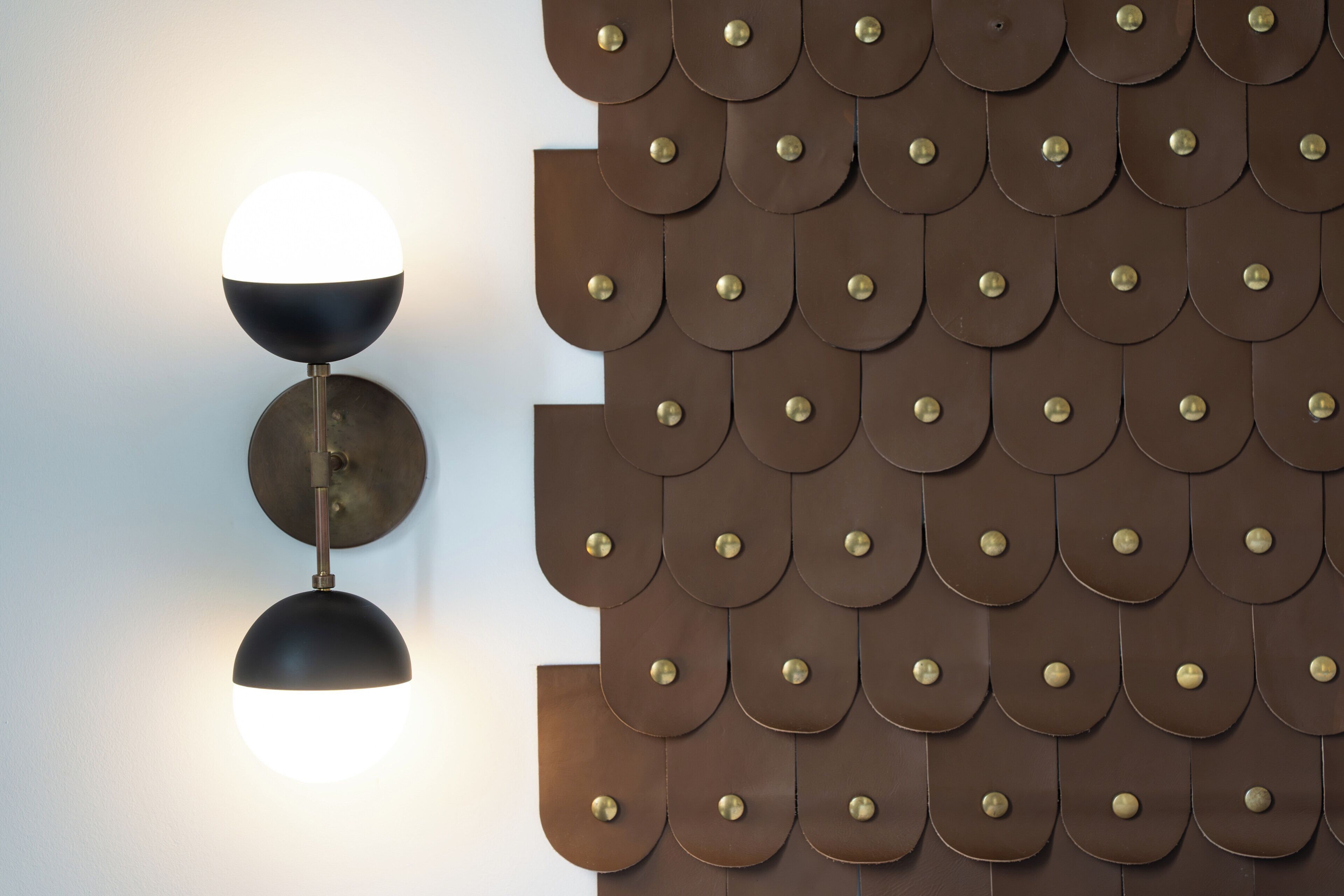 A wall-mounted light fixture with a spherical shade and a metallic base.