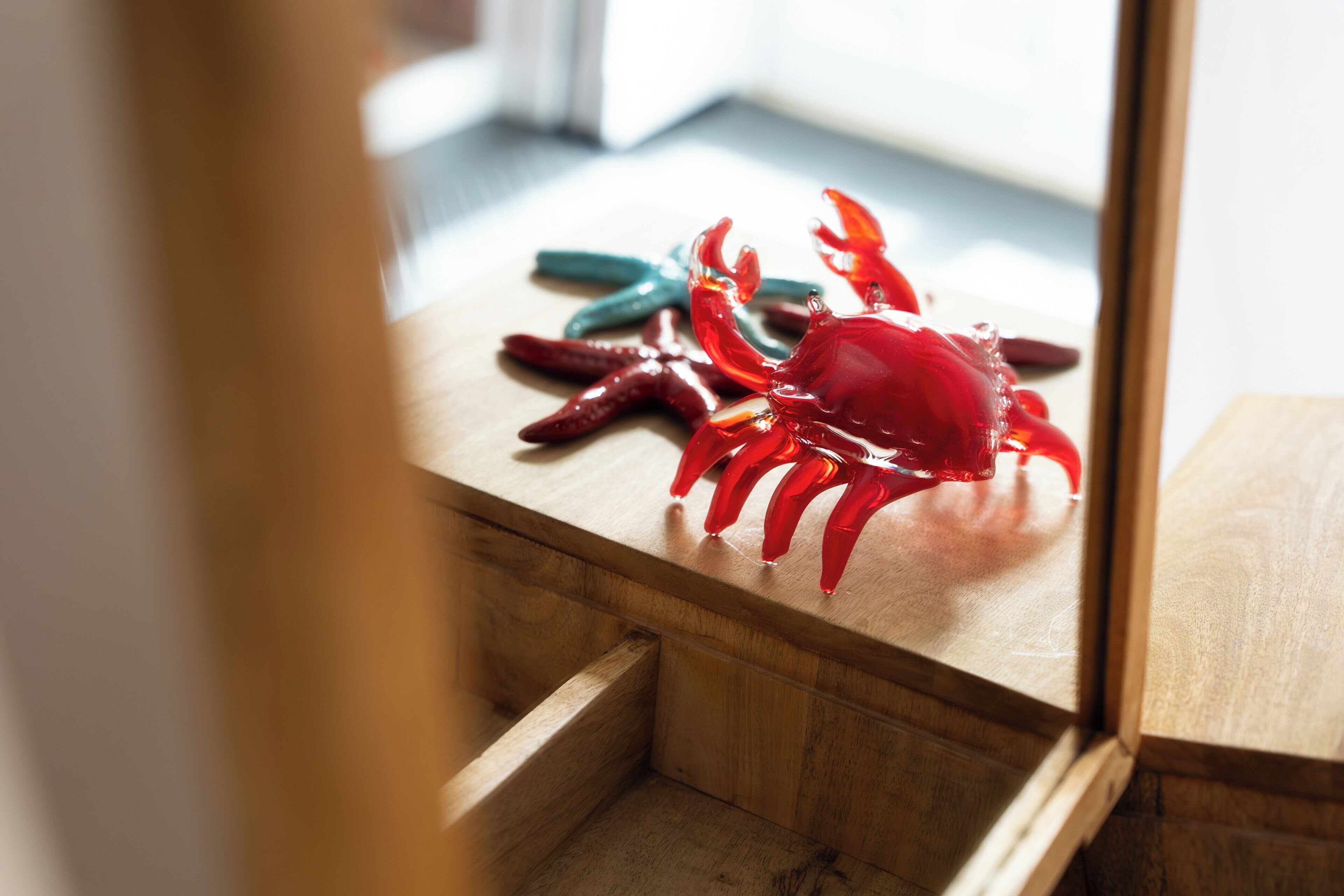 A wooden drawer with a red crab and a green starfish on top.