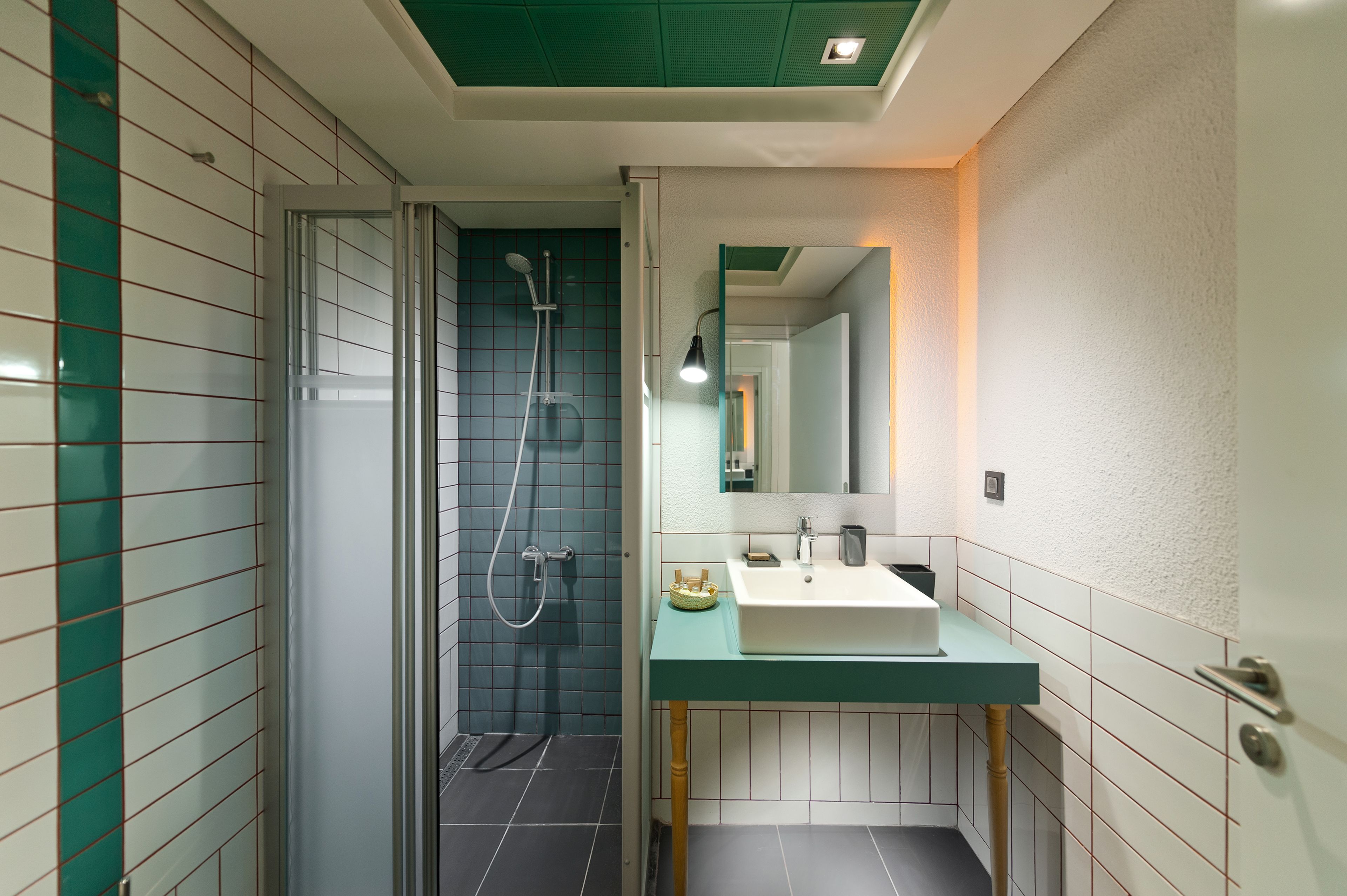 A bathroom with a shower, a sink, and a mirror.