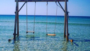Un columpio de madera en agua clara y poco profunda.