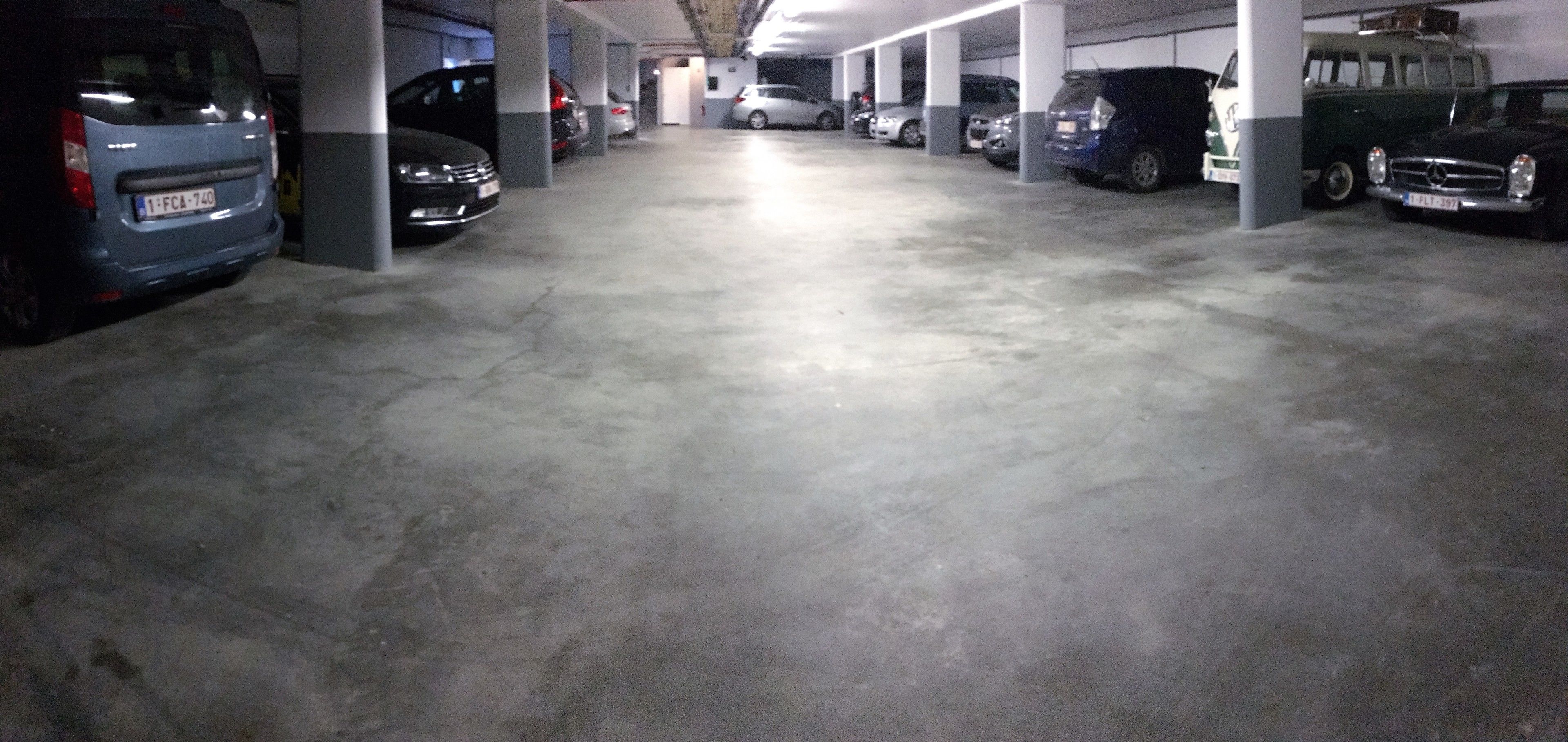 Un parking à plusieurs niveaux où plusieurs voitures sont garées en rangées.