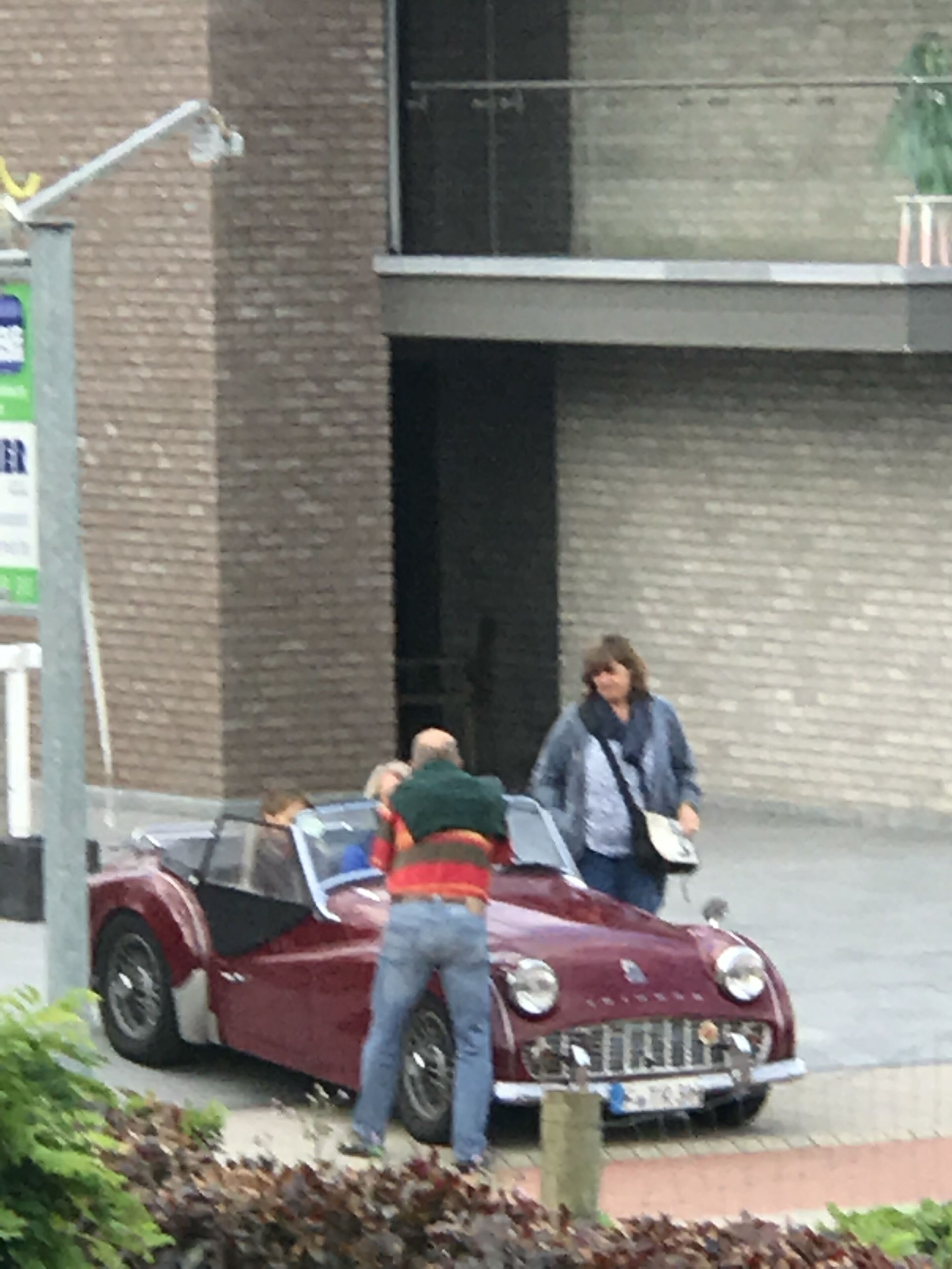 Un coche clásico estacionado frente a un edificio de fachada de ladrillo.
