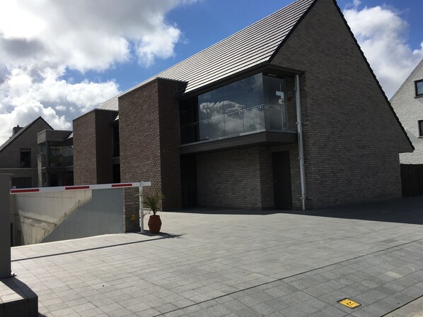 A modern building with a brick facade, large windows, and a flat roof. - Logies Ternier (Nieuwpoort)