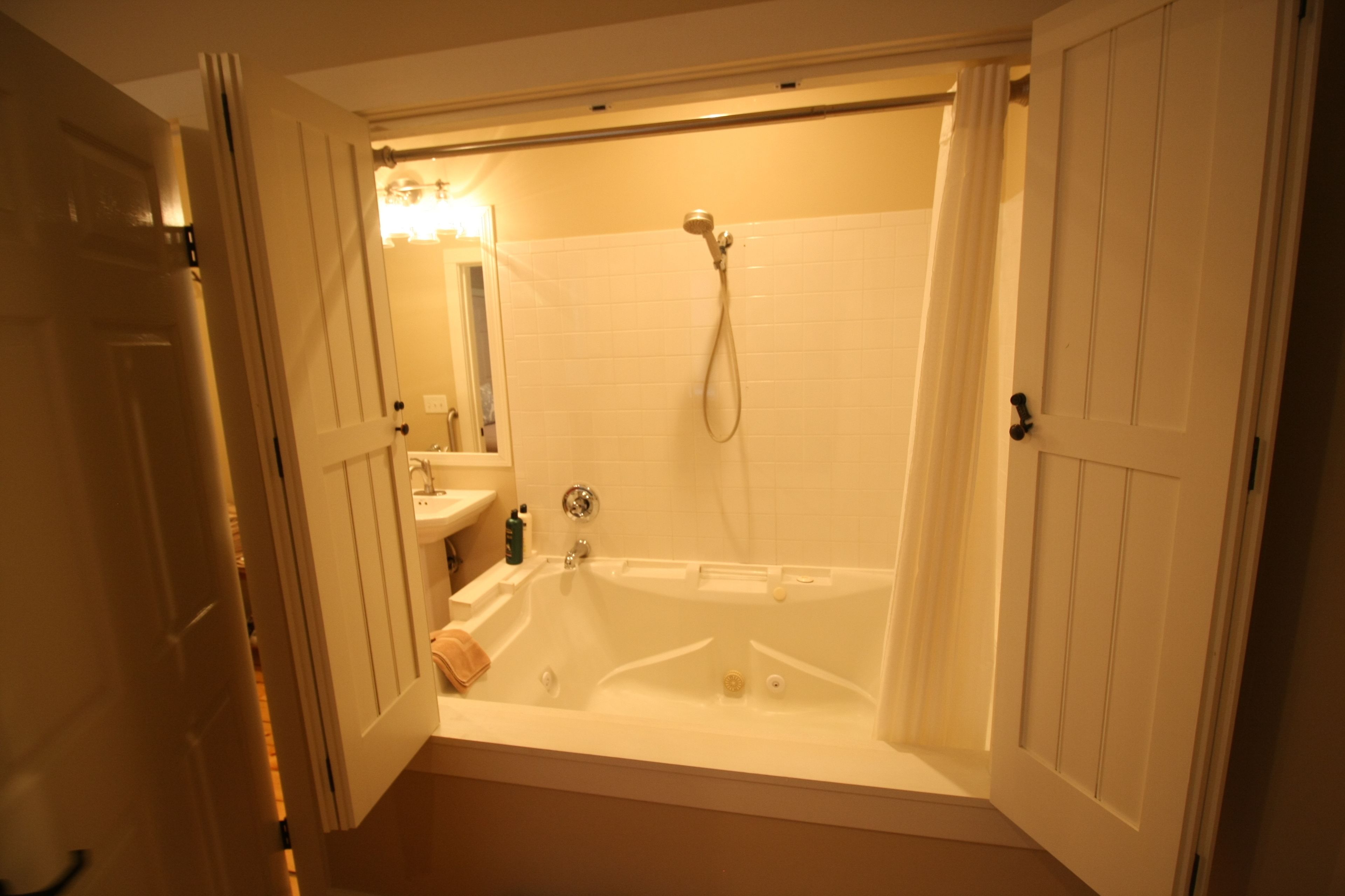 A bathroom with a bathtub, a shower, a sink, and a mirror.