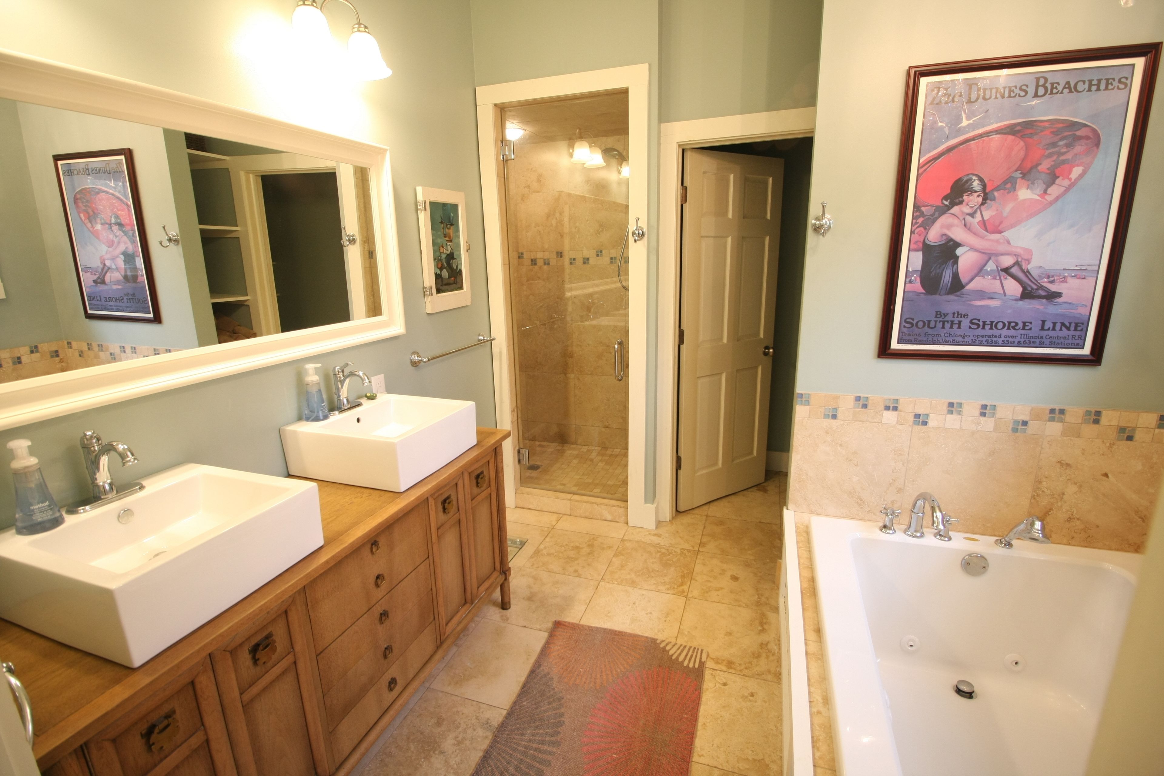 A bathroom with two sinks, a bathtub, and a shower.