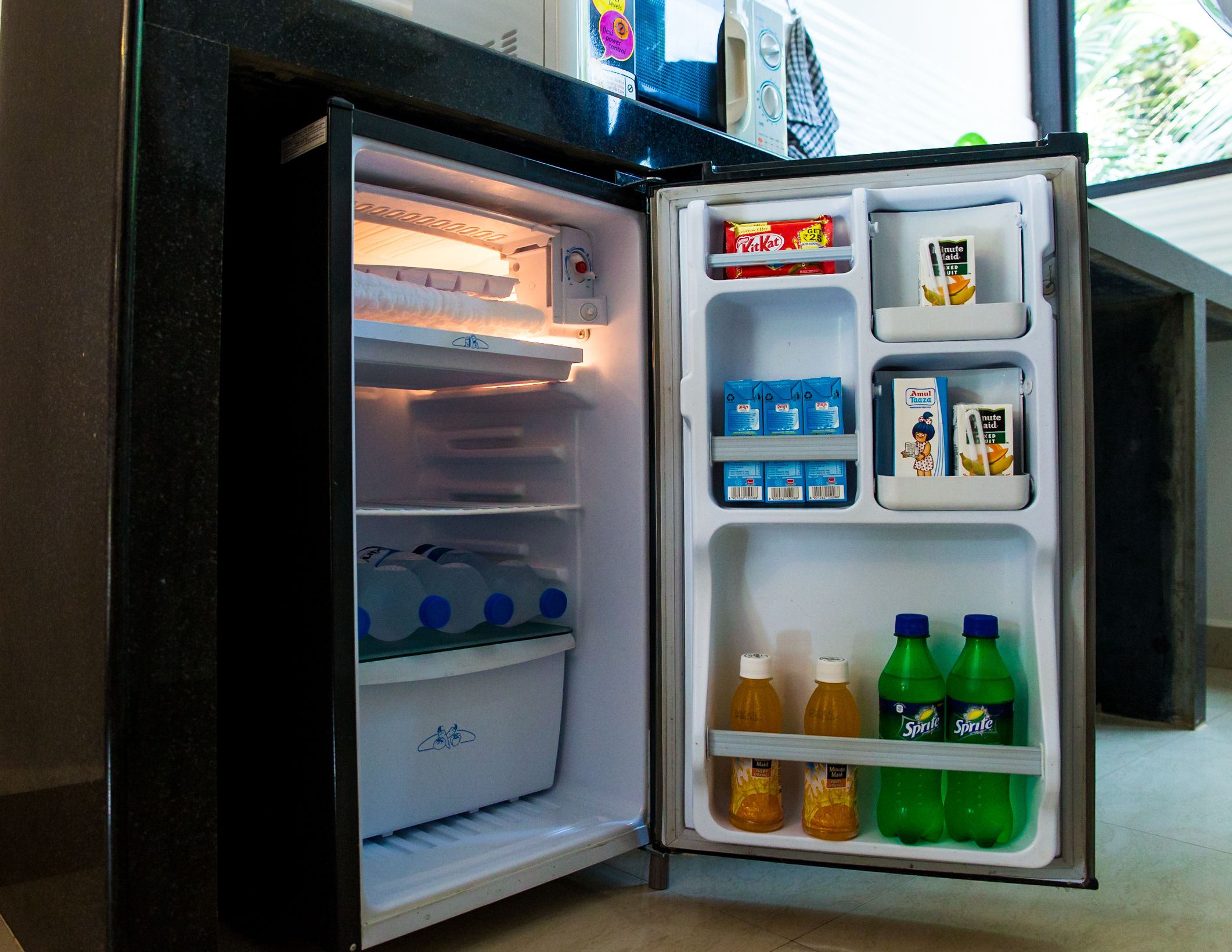 An open refrigerator with milk cartons, juice bottles, and packaged snacks.