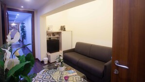 Una sala de estar con un sofá, una mesa de centro y un mueble bajo para la televisión.