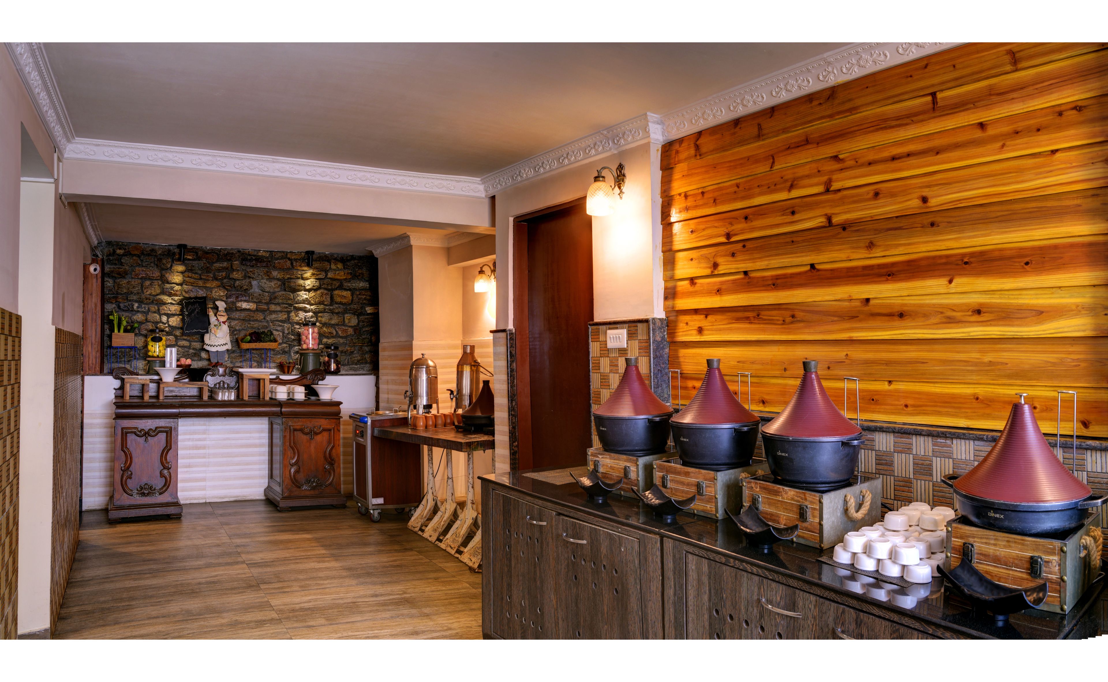 A kitchen with a stone wall, wooden cabinets, and a wooden wall panel.