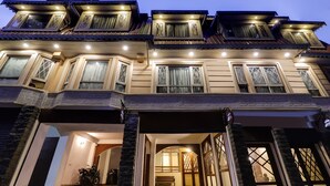 A multi-story building with a traditional architectural style, featuring multiple balconies and large windows. - Summit Hermon Hotel & Spa (Darjeeling)