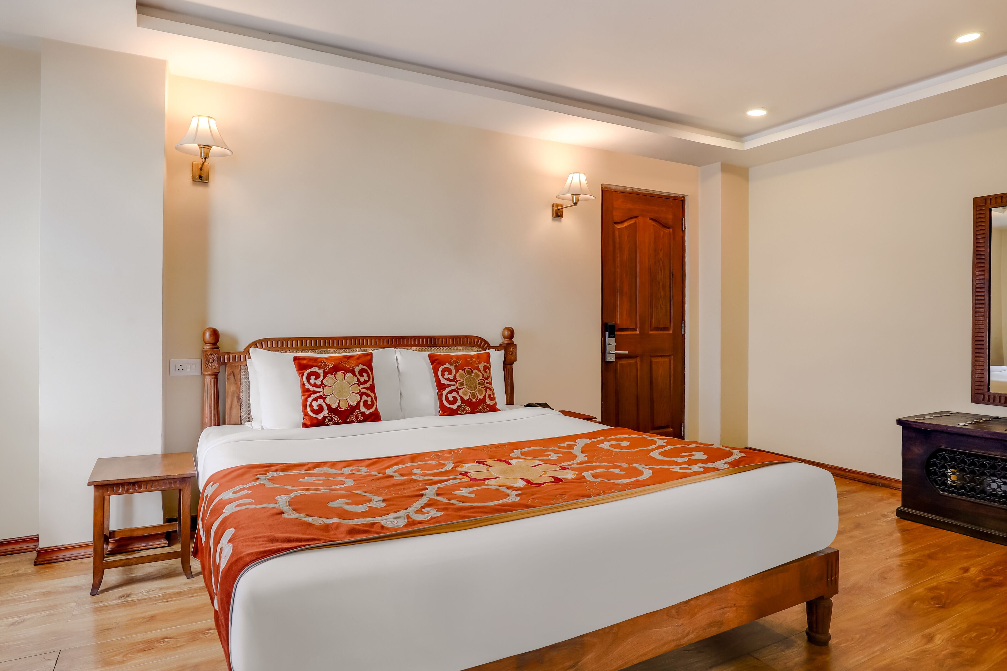 A neatly arranged bedroom with a wooden bed, a bedside table, and a nightstand.