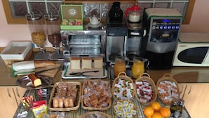Un buffet de petit-déjeuner proposant une variété d’aliments, notamment du pain, des viennoiseries et des boissons.
