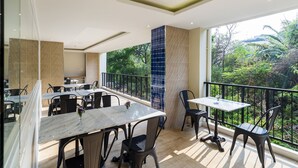 Ein Restaurant mit Terrassensitzgelegenheiten, Blick auf Grünflächen und modernem Interieur.