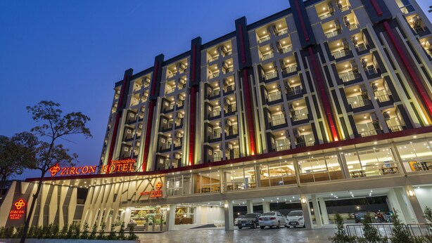 Ein mehrstöckiges Hotel mit moderner Fassade, mehreren Balkonen und einem gut beleuchteten Eingang.
