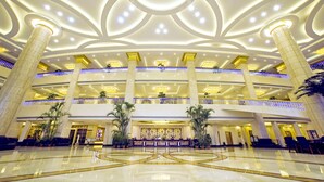 Eine geräumige Lobby mit einer zentralen Rezeption, mehreren Etagen und einem modernen Deckenstil.